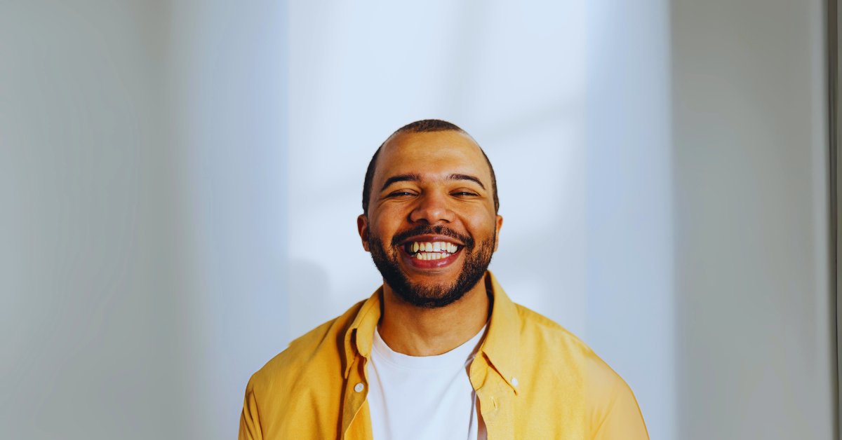 A smiling man in a yellow shirt, symbolizing the effects of drugs that make you happy naturally.