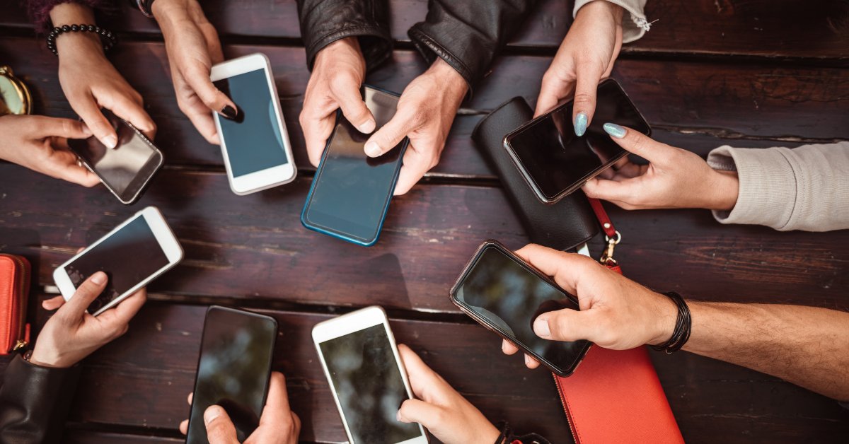 A group of people using smartphones, symbolizing the impact of social media addiction.