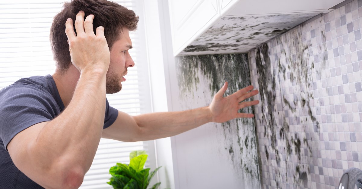 A man shocked by mold on a wall, symbolizing mold and addiction's strange connection in health issues.