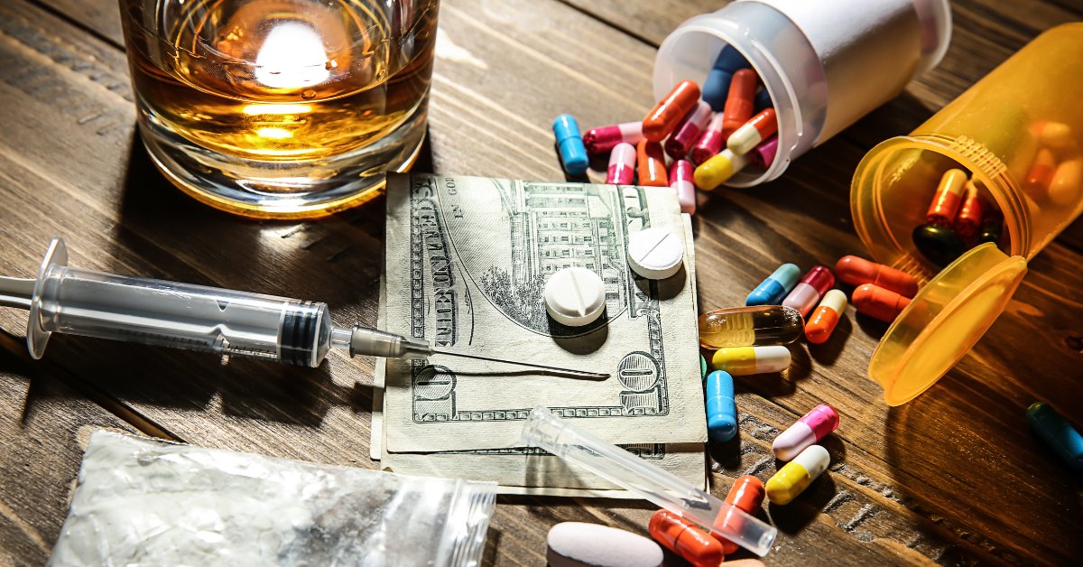 A syringe, pills, and alcohol on a table with money, representing the risks of alcohol and Accutane interaction.